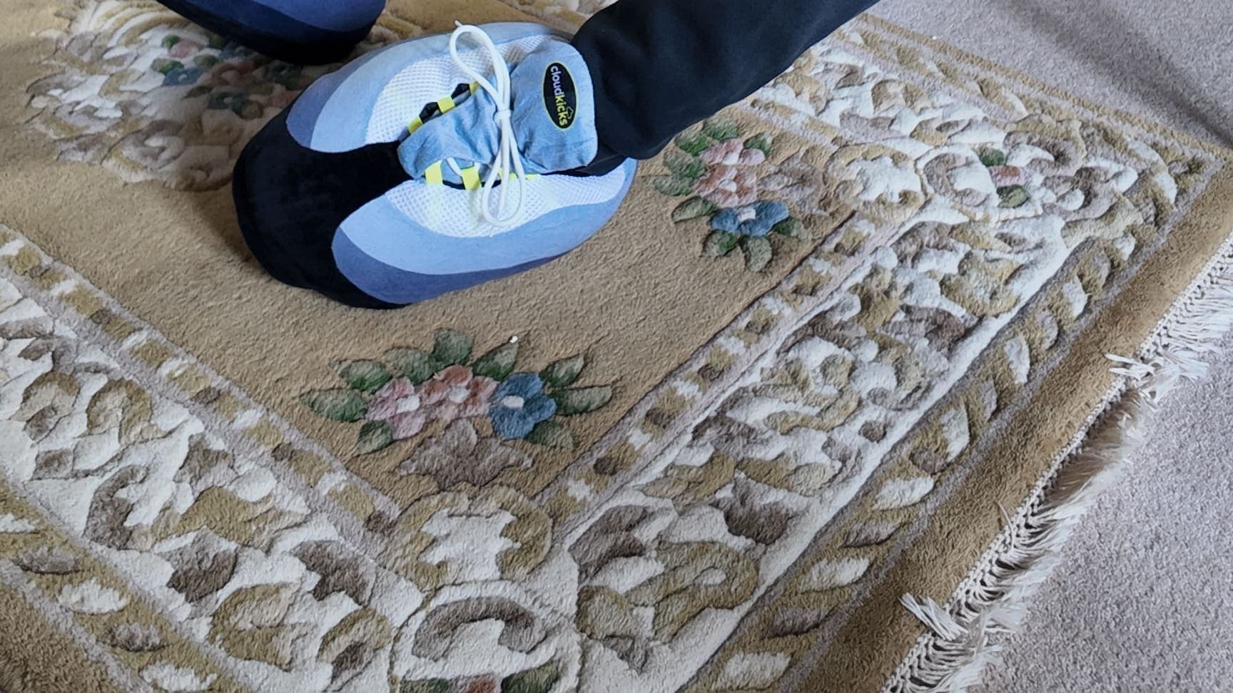 An OG Neon CloudKick on a patterned rug, navy joggers above