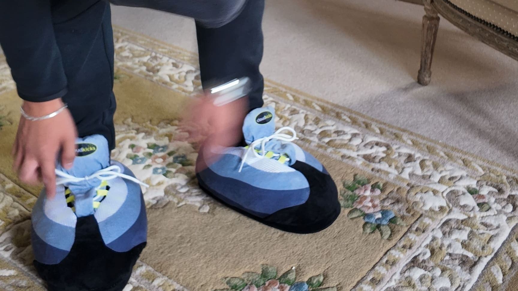 Bending down to lace up a pair of OG Neon CloudKicks on a patterned rug
