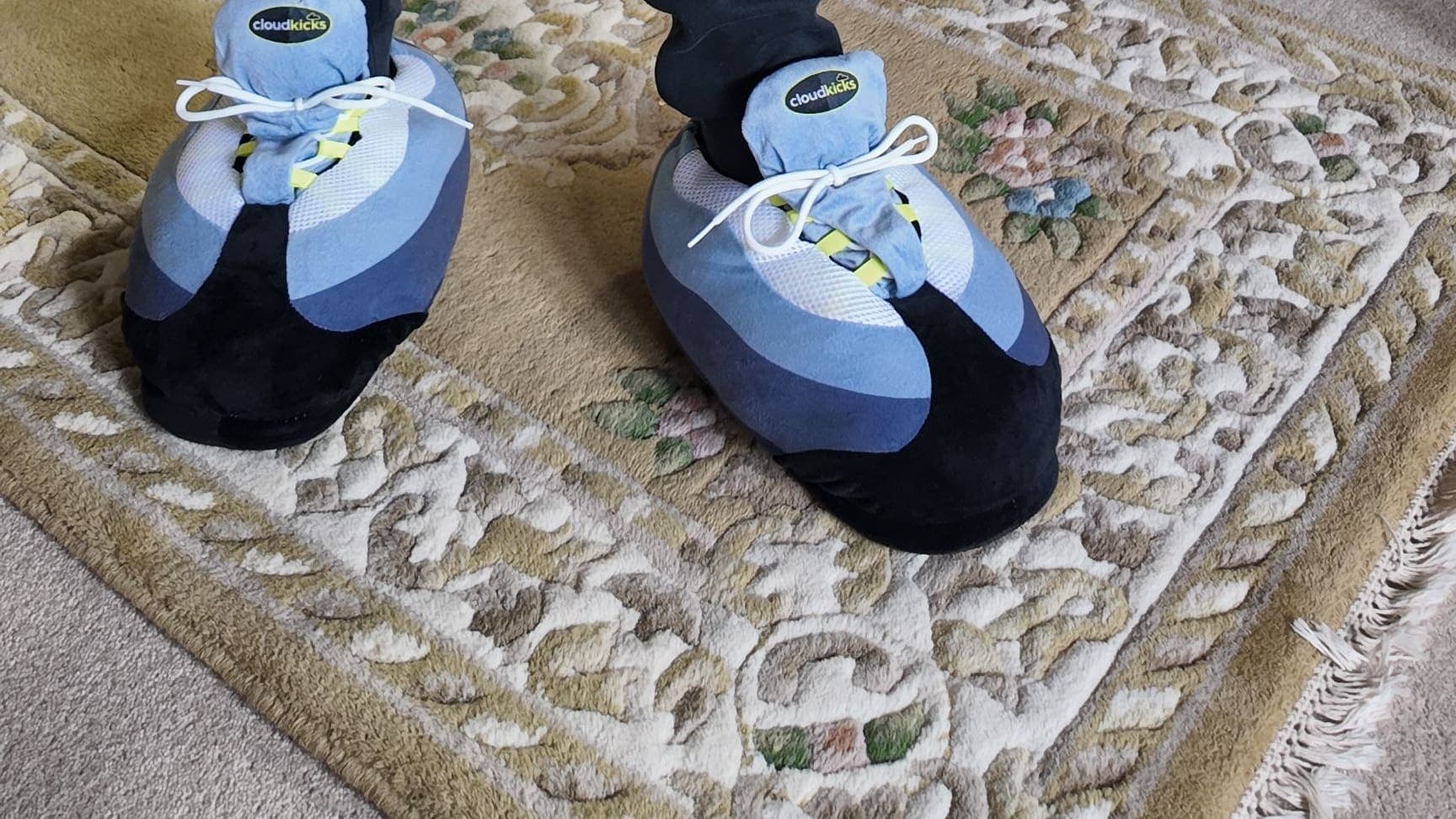 OG Neon CloudKicks standing on a patterned rug, navy joggers above