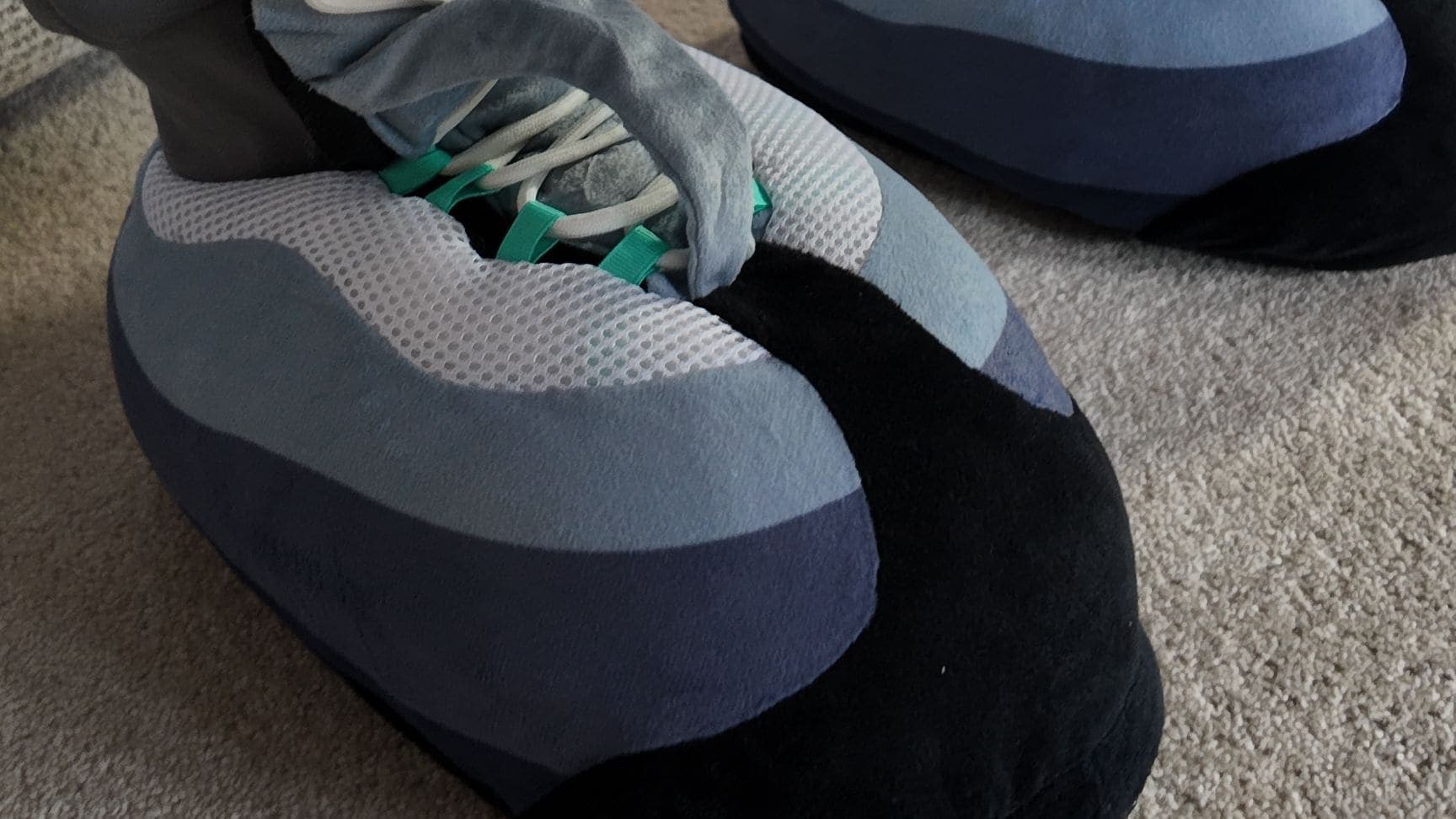 Hyper Turquoise CloudKicks on a cream carpet, grey joggers above