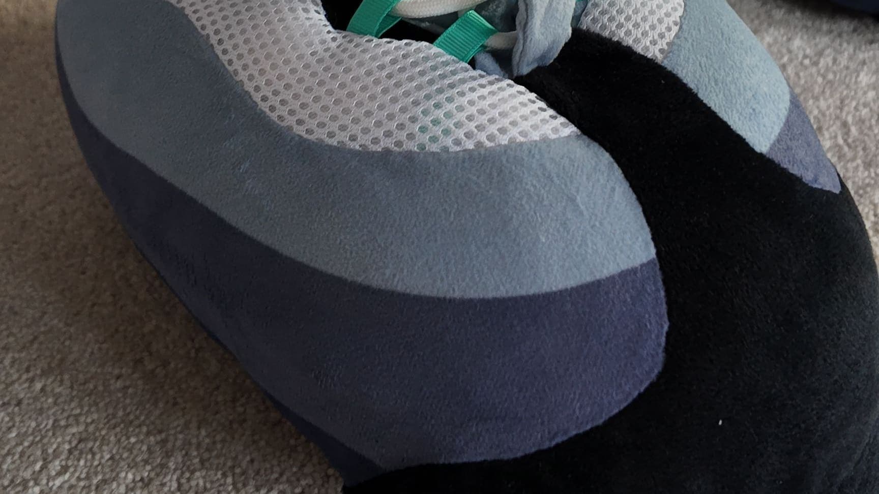 Close-up of a Hyper Turquoise CloudKick on the carpet, turquoise lace loops just showing