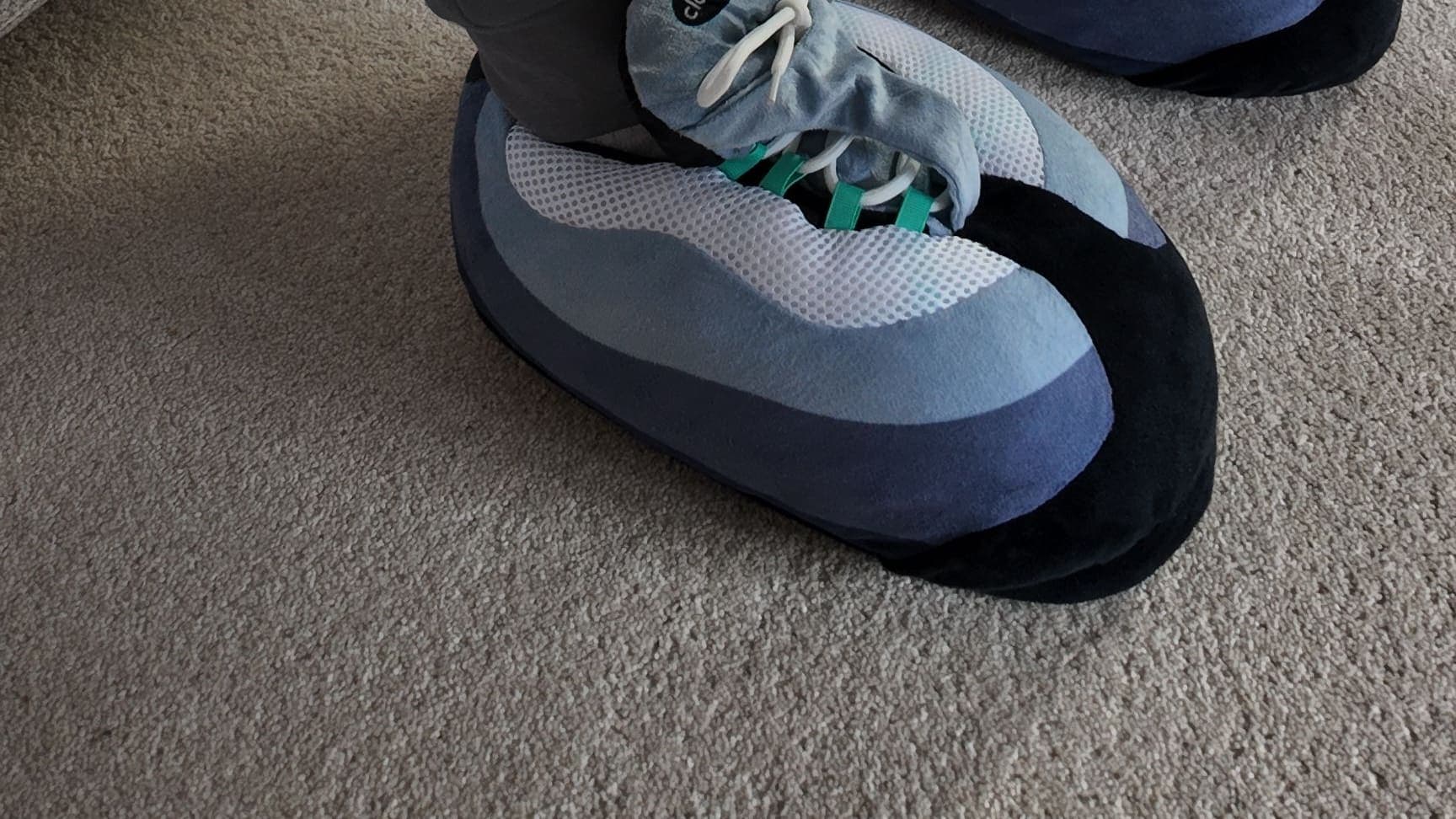 A Hyper Turquoise CloudKick on the living-room carpet, grey joggers above