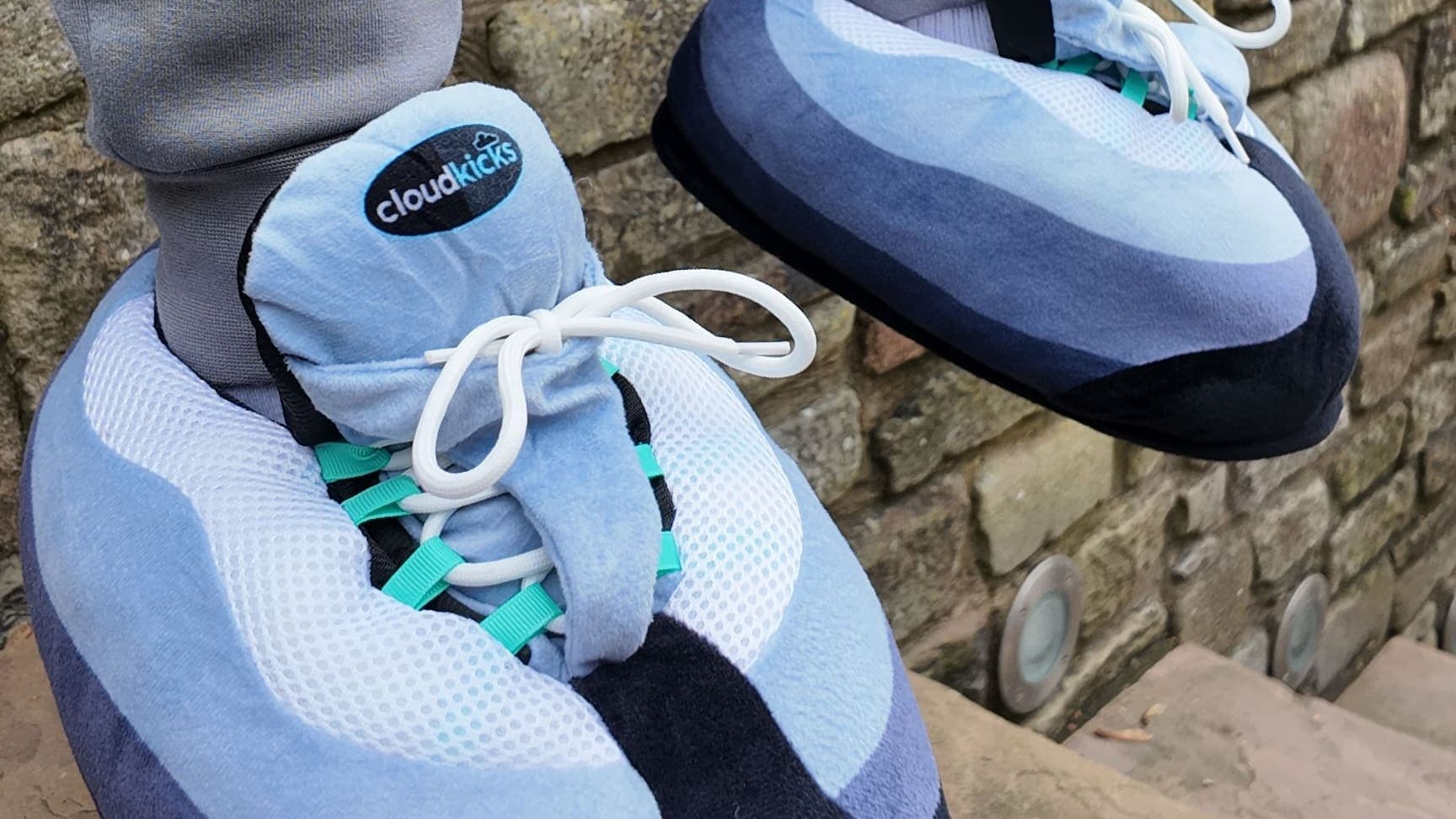 One foot up on a stone step in Hyper Turquoise CloudKicks